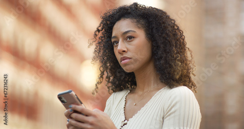 Young black woman using smartphone on a city street