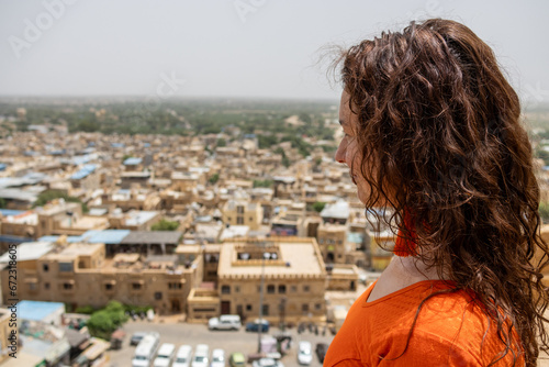 Woman looks down on the city from the Jaisalmer Fort in Rajasthan, India. The golden city of the Thar desert © angel