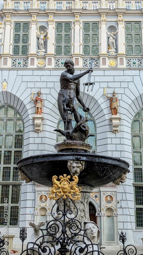 Intricately detailed bronze statue in the center of a fountain in the city of Gdansk, Poland