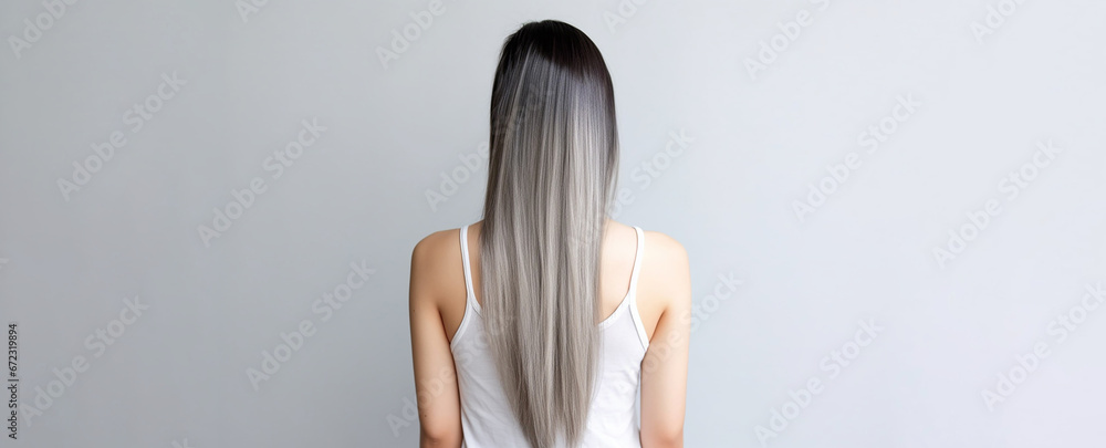 Obraz premium The rear view of a young woman with sleek, silver long hair, photographed in a studio with a white background and professional lighting. Generative AI.