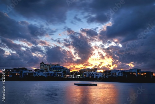 clouds moving over the water and buildings at sunset time at the coast