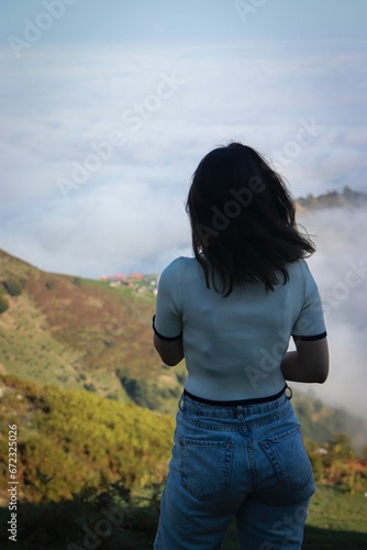 Young woman standing atop a hill