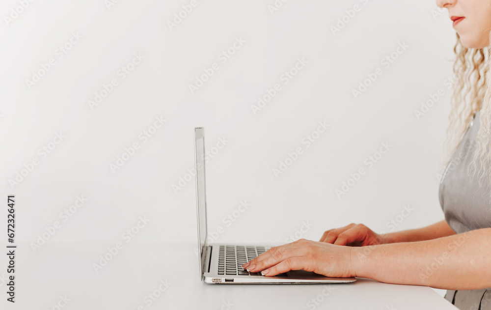 Fototapeta premium Woman working with laptop, side view, white background, minimalism