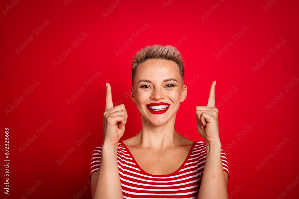 Photo of cheerful adorable girl wear stylish clothes presenting empty space buy novelty beauty product isolated on red color background Photo of cheerful adorable girl wear stylish clothes presenting empty space buy novelty beauty product isolated on red color background