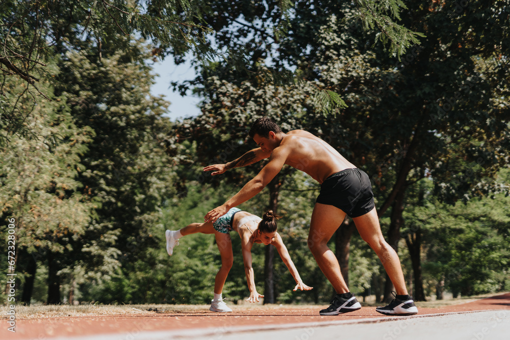 Obraz premium Fit athletes perform cartwheels in the park on a sunny day. These sporty friends inspire a healthy lifestyle with their dedication to physical activity and positive results.