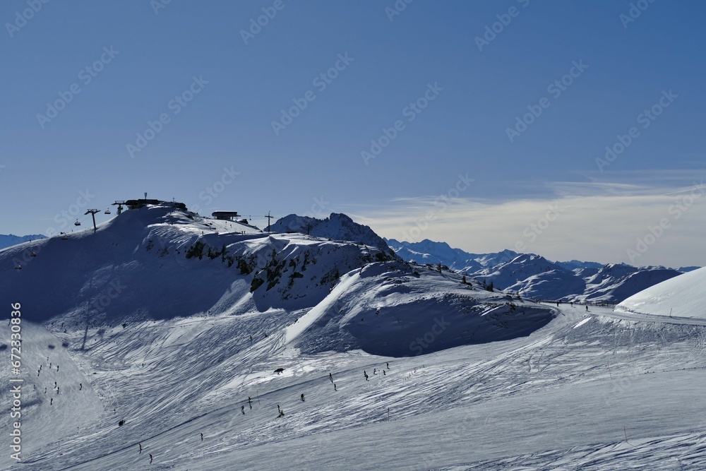 people ski up the slopes near a snowy mountain top with lift lift