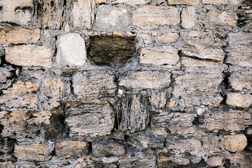 Fototapeta premium a large stone wall with a bricked up window and one bricked off
