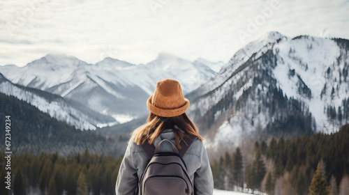 backside of young woman looking at snowy mountains photo