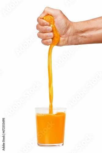 someone is squeezing an orange into the glass of juice as if it was being squeezed photo