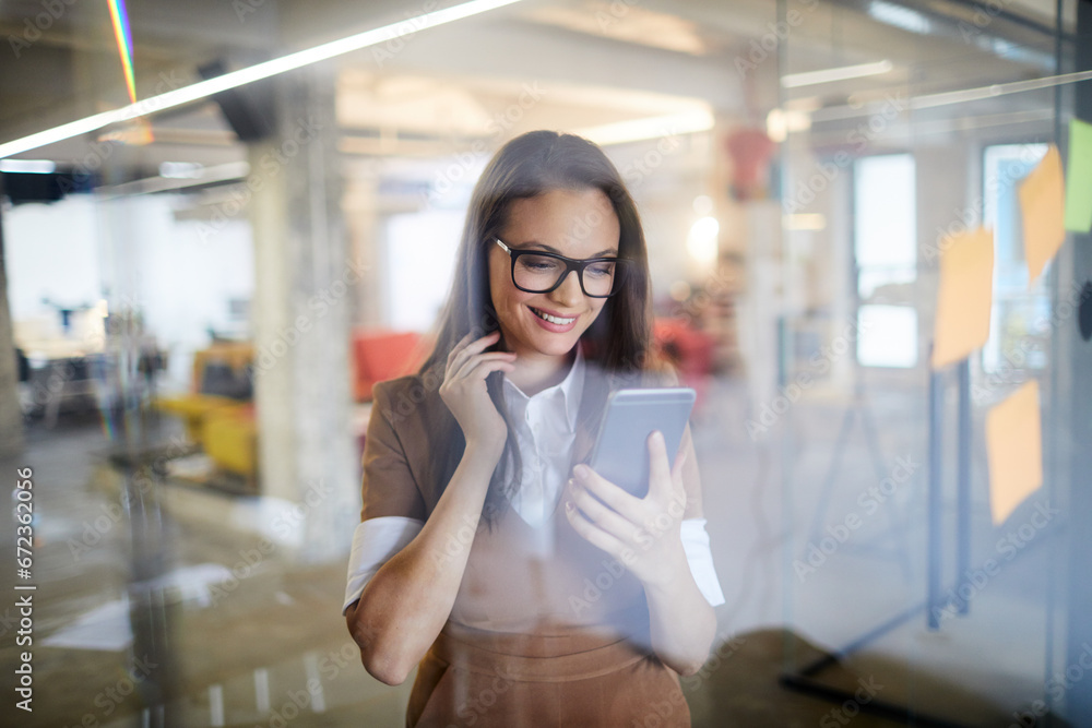 Smiling businesswoman holding a smartphone in a office