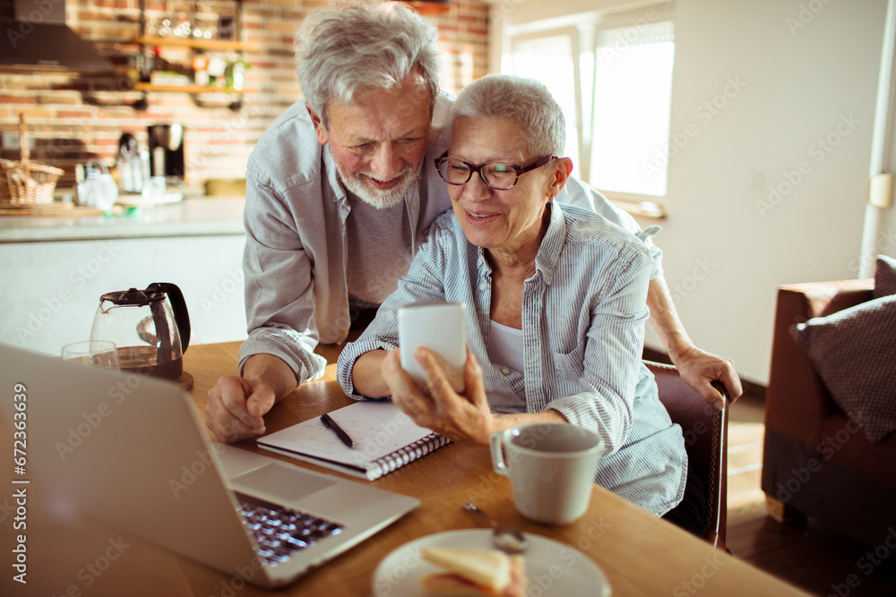 Senior couple using a smartphone together at home Senior couple using a smartphone together at home