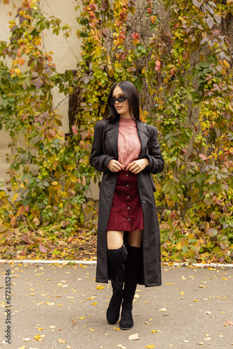 Schilderij op canvas Young woman in black sunglasses, leather raincoat and pink turtleneck