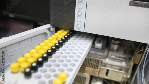 A tray with samples and reference standards is placed in a laboratory chemical equipment intended to find trace levels of contaminants in food, water and biological samples as blood and urine photo