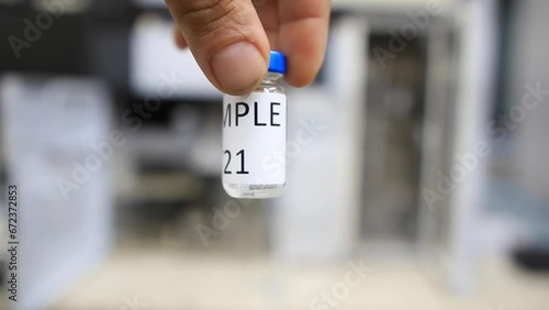 A man holds a vial with a sample of water to perform trace analysis looking for pesticides, organic solvents and heavy metals  photo