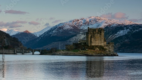 Majestic Eilean Donan castle on the shore with tranquil waters and mountains in the background