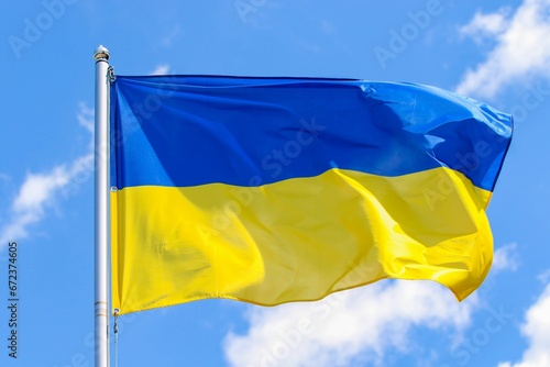 The national flag of Ukraine against a backdrop of blue sky