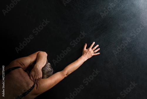 prone person with hand reaching towards light