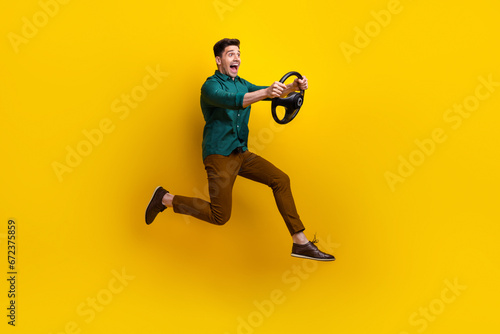 Photo of funky cheerful man in trendy clothes test drive lesson speed vehicle road looking empty space isolated on yellow color background