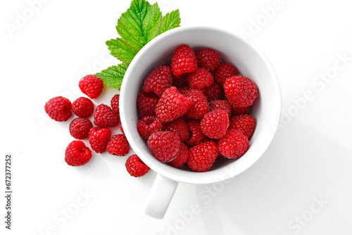 maliny w białym kubku, czerwone maliny, maliny z zielonym listkiem, fresh raspberries in a cup, red raspberries, juicy raspberries with a green leaf, Rubus idaeus, rasberry view from above,białe tło