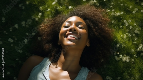 Smiling young black woman lying on the grass