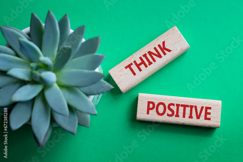 Think Positive symbol. Concept word Think Positive on wooden blocks. Beautiful green background with succulent plant. Business and Think Positive concept. Copy space