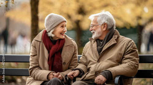 An elderly couple shares a joyous moment on a park bench, their smiles and laughter radiating warmth and deep connection amidst an autumnal backdrop. © MP Studio