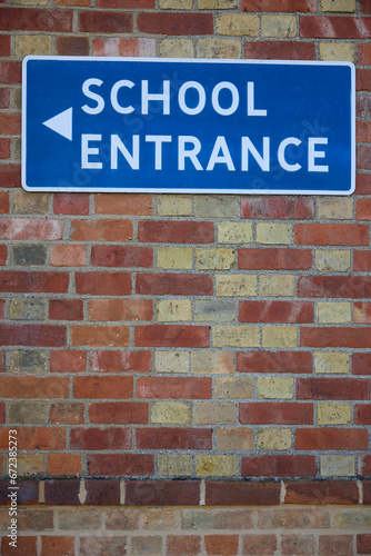 School Entrance Sign On Brick Wall Of School Building
