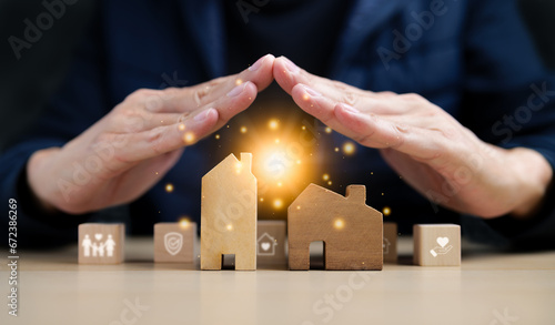 Insurance House and family health live concept. A hand covering a model of a house along with some wooden blocks. Property Insurance, Home protect insurance, care family practice, Safety estate, photo
