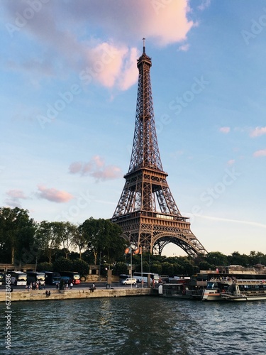 Stunning outdoor shot of the iconic Eiffel Tower in Paris, France against a cloudy blue sky © Wirestock