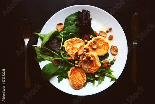 Healthly food. Healthy breakfast. Cheesecakes and salad. Food on a plate, top view. Table setting.