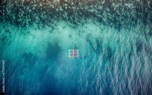 Aerial view of white and red bankga boat in blue and turquoise sea by the algal shore photo