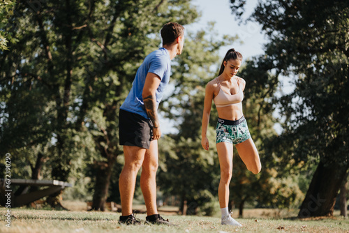 A fit Caucasian couple exercises outdoors in a park, enjoying a sunny day and engaging in challenging workouts. They stretch, warm up, and practice recreational sports.