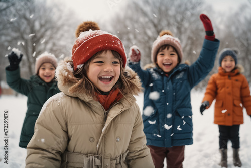Cheerful children in the park playing in the snow in cold winter day