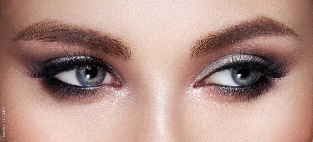 Fototapeta premium Beautiful female eyes with long eyelashes. Eyelash extensions. Makeup, cosmetics, beauty. Close up, macro