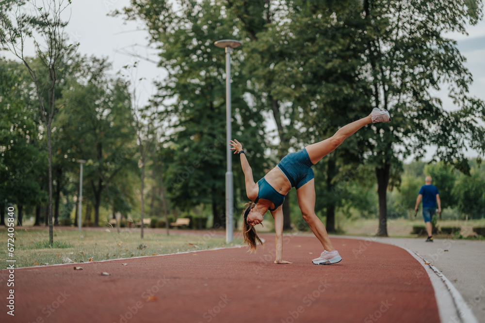 Active, fit girl display impressive 360-degree cartwheels in a green park, inspiring with their athleticism and dedication to exercise. Perfect for fitness and sports projects.