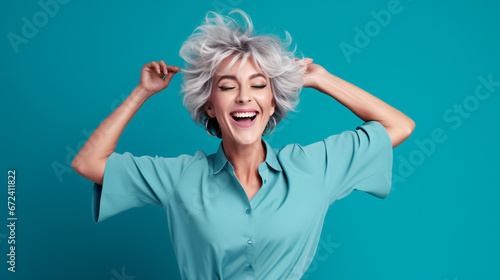 Portrait of attractive cheerful grey-haired woman dancing having fun rejoicing isolated over bright teal turquoise color background