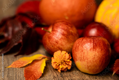 Red apples on the table. Autumn arrangement of apples and pumpkins