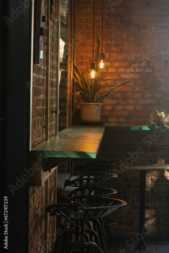 Contemporary bar setting with a row of chairs and a brick wall in the background
