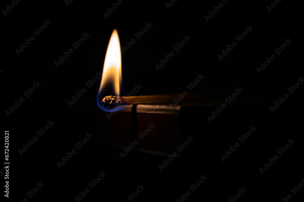 Closeup of a burning matchstick in the dark Closeup of a burning matchstick in the dark