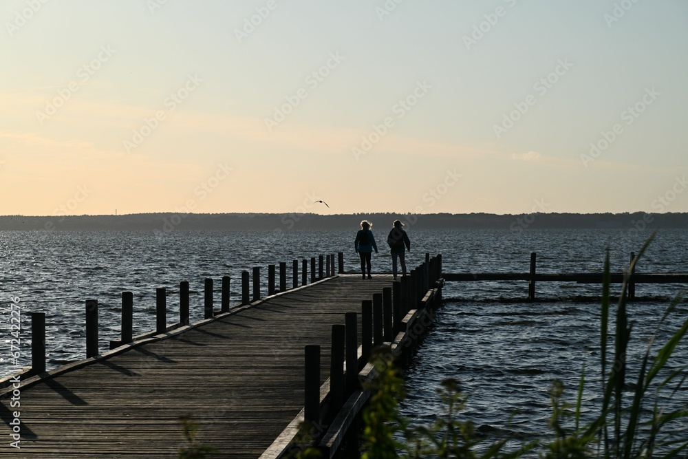Silhouetted figures on the wooden dock on a windy day Silhouetted figures on the wooden dock on a windy day