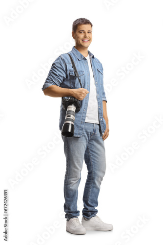 Full length portrait of a male photographer carrying a professional camera and smiling