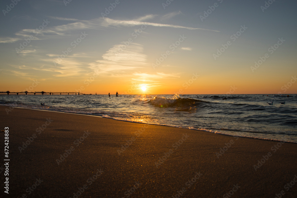 Złota plaża o za chodzie słońca w Między zdrojach