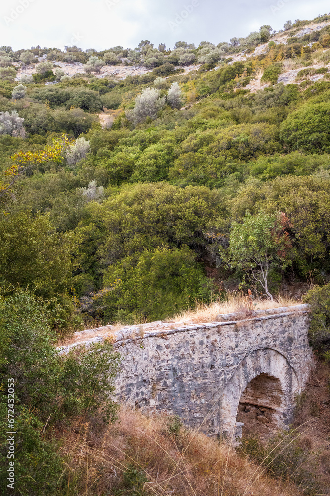 Old Kavala nature hiking trail, ancient stone bridge into the woods, Greece