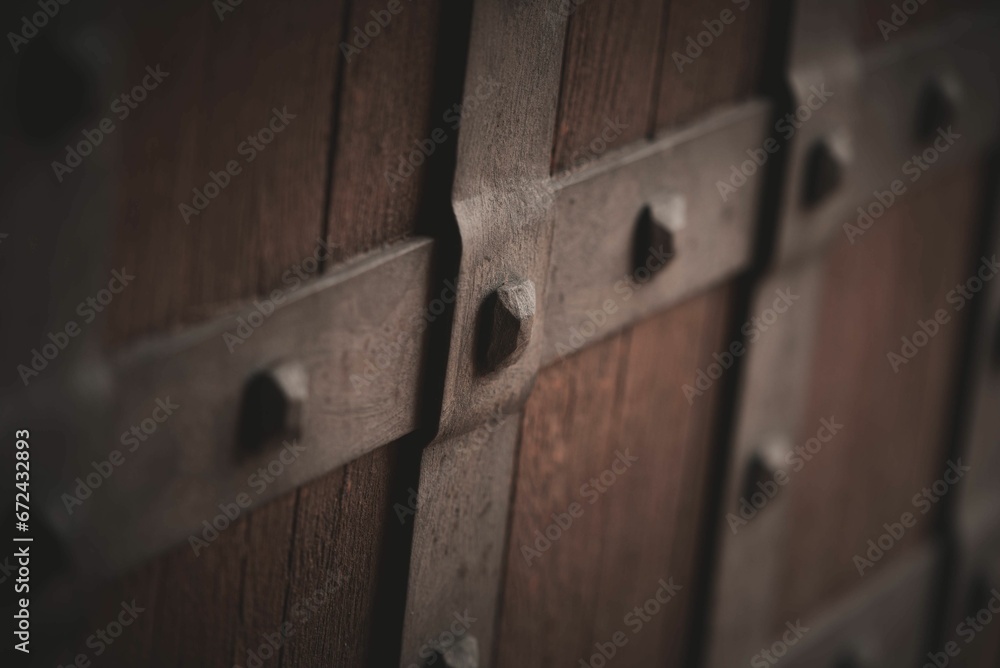 Close-up of a brown wooden wall with visible rust-covered bolts