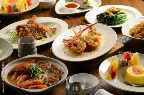 Long, wooden table is filled with an abundance of seafood dishes and cutlery