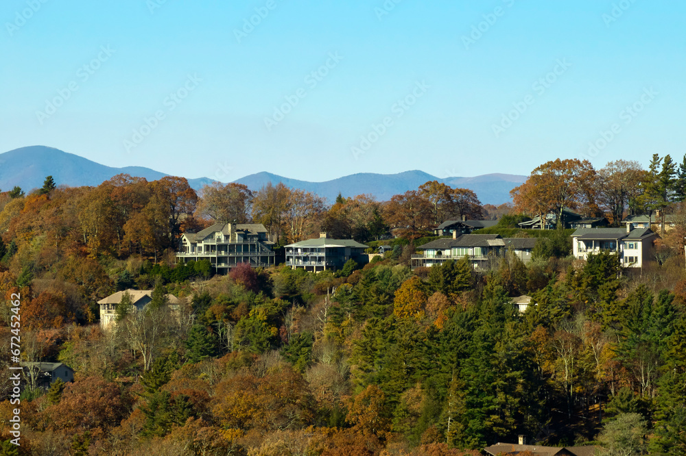 Naklejka premium Aerial view of expensive american homes on hilltop in North Carolina mountains residential area. New family houses as example of real estate development in USA suburbs