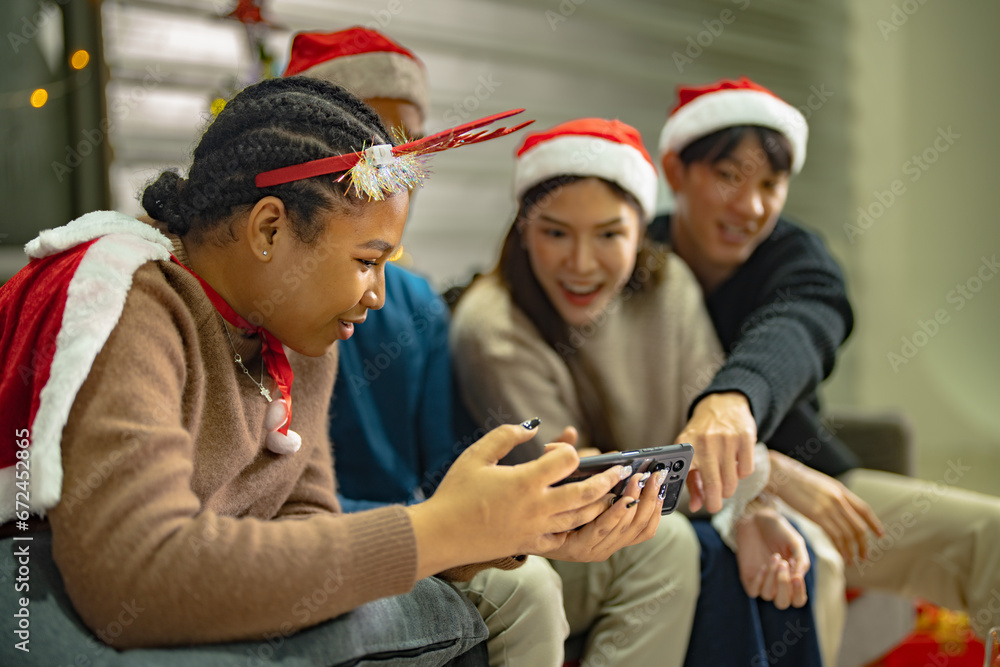 Fototapeta premium Party of asian Friends Enjoying Christmas Drinks and celebrating having selfie by smartphone. happiness women and man christmas eve celebrate dinner with food and beverage.