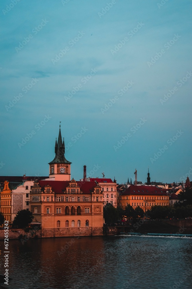 Fototapeta premium Majestic building set atop a hill overlooking a tranquil river in Praha, Czech Republic