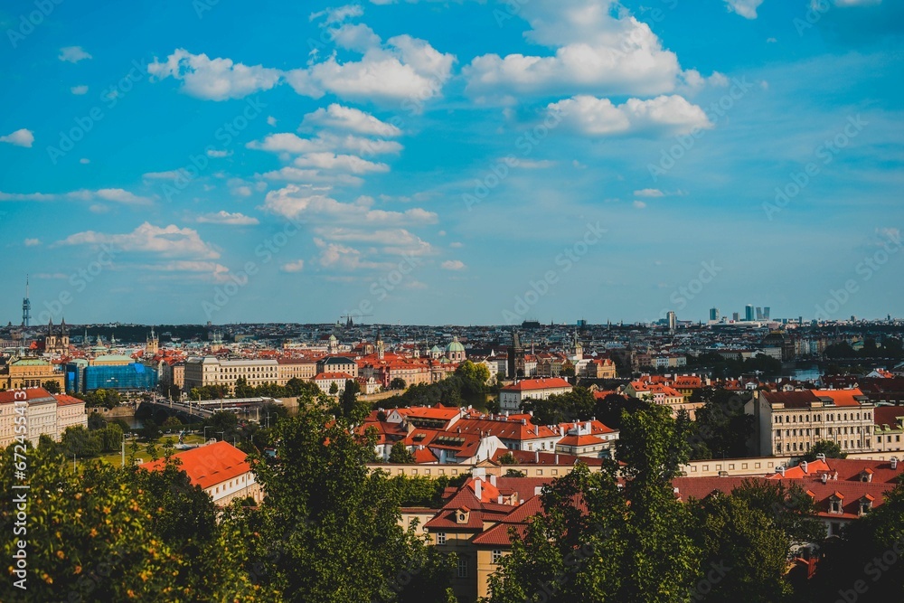 Aerial view of the cityscape of Prague with its vibrant red rooftops, seen from a distance