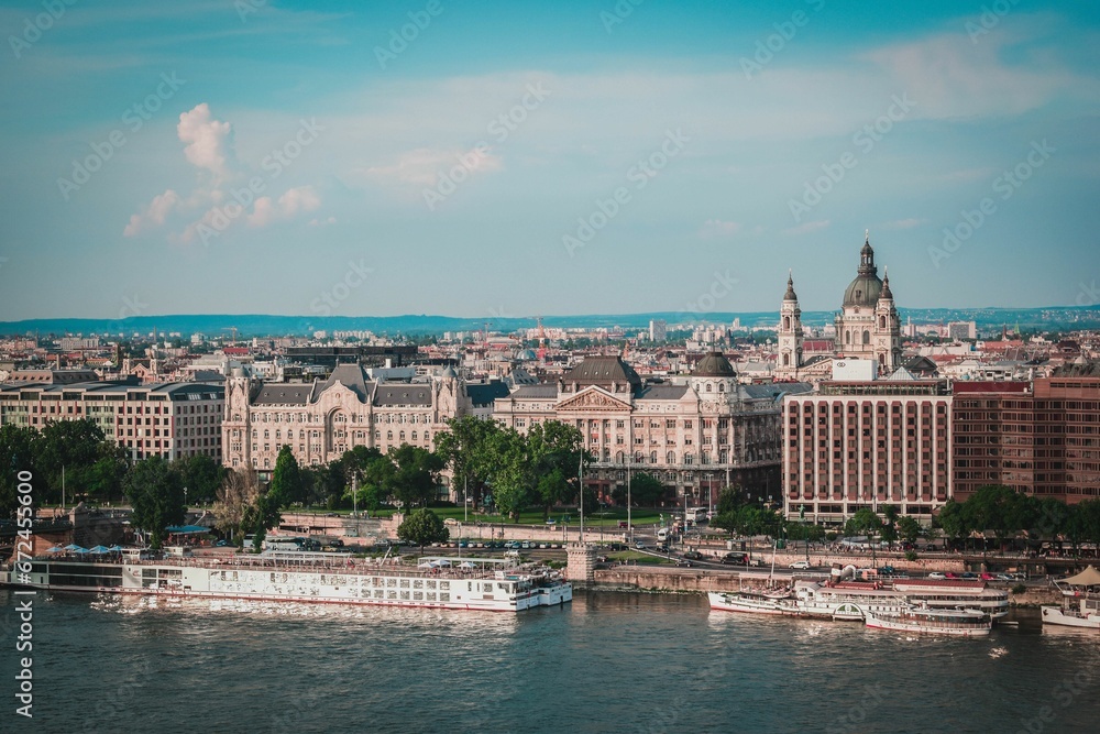 Scenic view of a bridge spanning a river with a city skyline in the background in Budapest